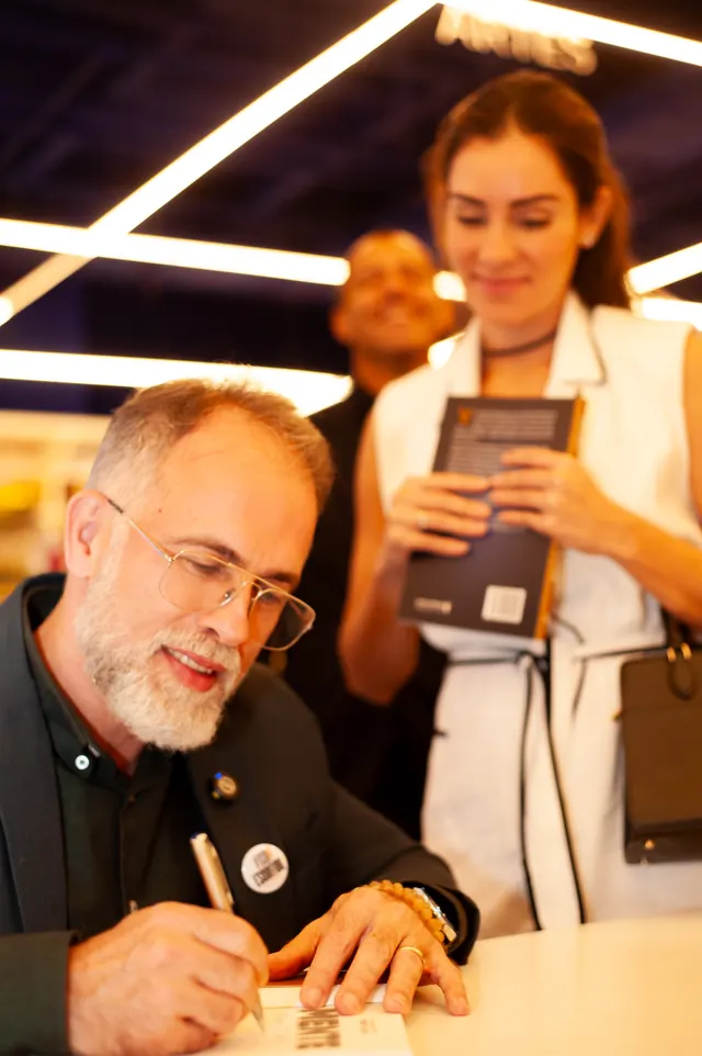 Autor autografando livro